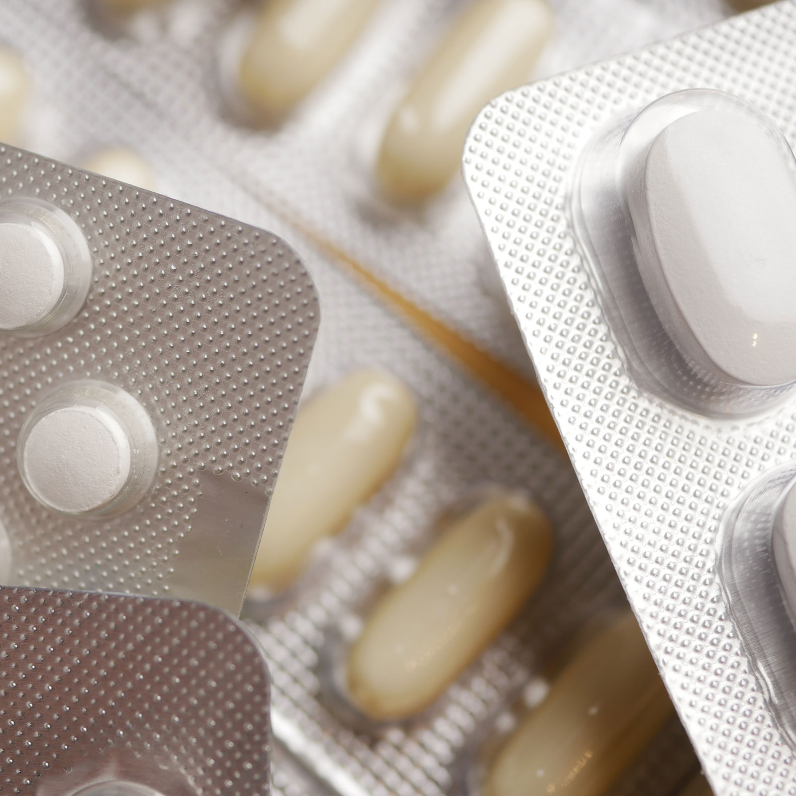 Nahaufnahme von verschiedenen Medikamentenblistern und Tabletten, symbolisiert den Medikationscheck.